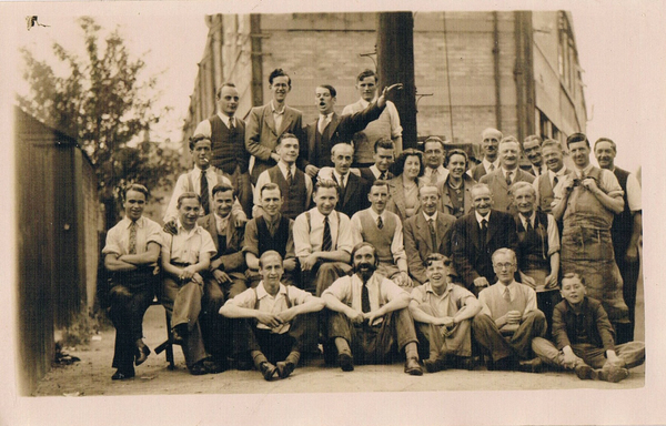 Luigi (Arthur) is 2nd from the right of the people seated on the chairs